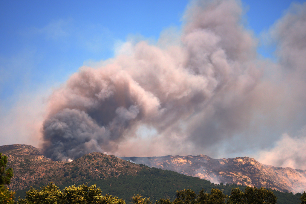 Tens of thousands of people flee raging wildfires in France and Spain, some escaping by boat